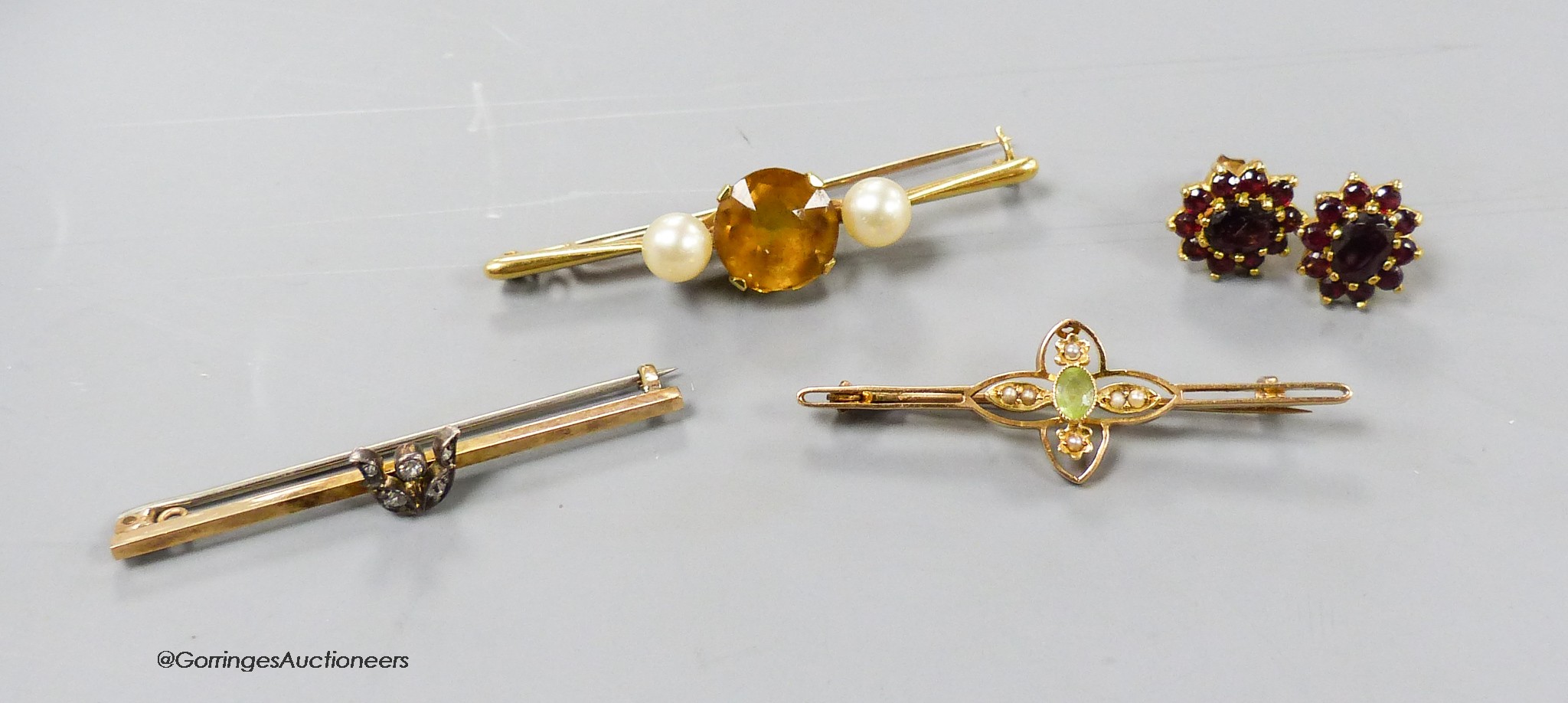 An 18ct, pt and gem set bar brooch, gross 6.8 grams, a similar 15ct bar brooch, gross 3 grams, gross 2.9 grams and a pair of 9ct and garnet cluster ear studs, gross 3 grams.